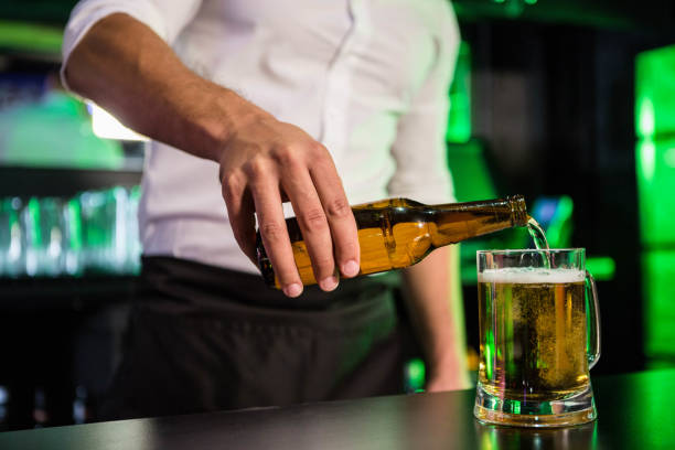 istock Mid section of bartender pouring beer in a glass 845474086