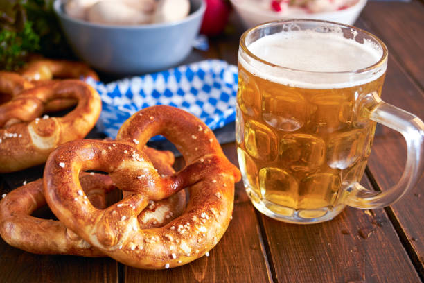 Beer Fest food on wooden table Traditional munich pretzel next to mug of beer on wooden tabele for Beer Fest. Close up. pretzel photos stock pictures, royalty-free photos & images