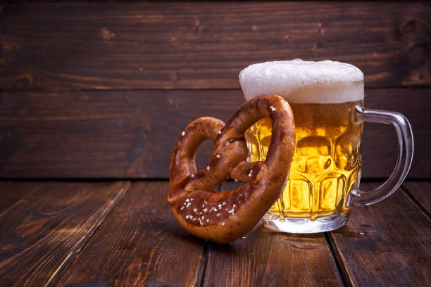 Beer Fest food on wooden background Mug of beer and pretzel for Beer Fest on wooden background. Copy space. oktoberfest beer stock pictures, royalty-free photos & images