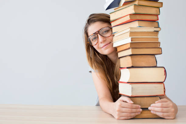 istock Happy student with a pile of books 845487350