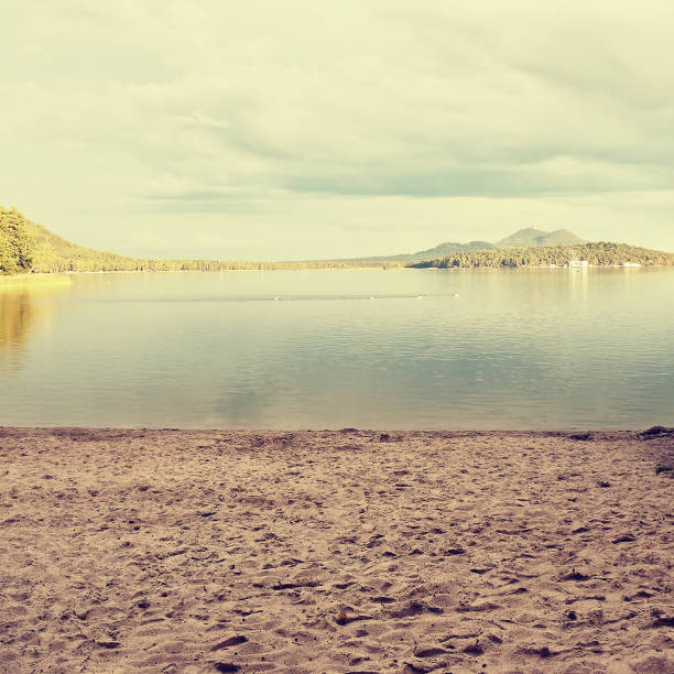 sandy beach by Macha's lake with Bezdez castle on horizont at sunset during sommer holidays in czech republic