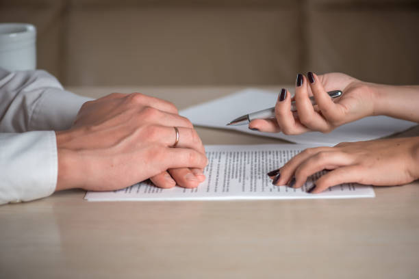 Hands of contractual parties, a woman and a man, signing a contract Hands of contractual parties, a woman and a man, signing a contract: business, premarital, loan, mortgage, credit, sales and purchase, investment agreement, divorce documents or other papers business party stock pictures, royalty-free photos & images