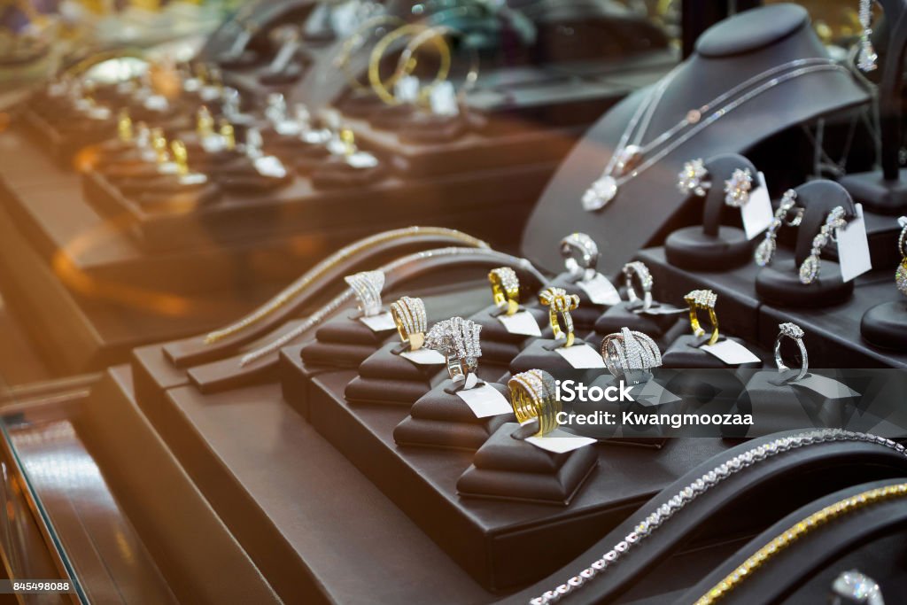 Gold jewelry diamond shop with rings and necklaces luxury retail store window display showcase Jewelry Stock Photo