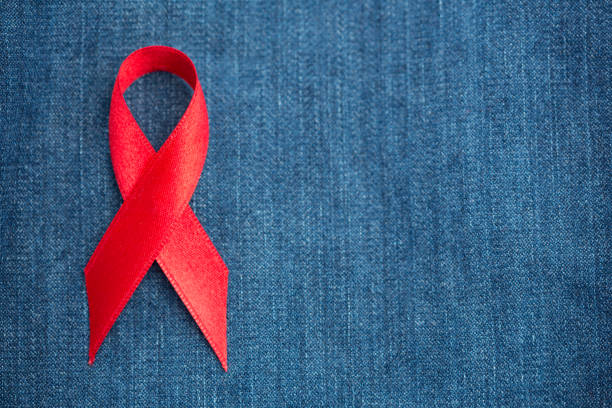 istock Red ribbon for aids awareness on denim 845498620