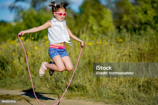 Girl Jumping With A Rope Stock Photo - Download Image Now - Jump Rope, Child, Outdoors