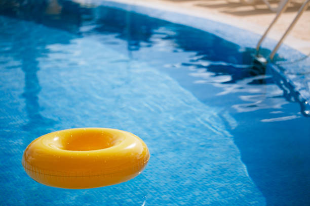 schwimmring auf blauem wasser cooles - swimming pool inner tube toy float stock-fotos und bilder