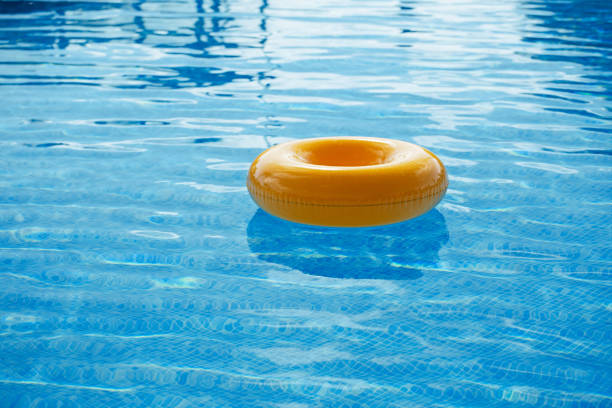 schwimmring auf blauem wasser cooles - swimming pool inner tube toy float stock-fotos und bilder