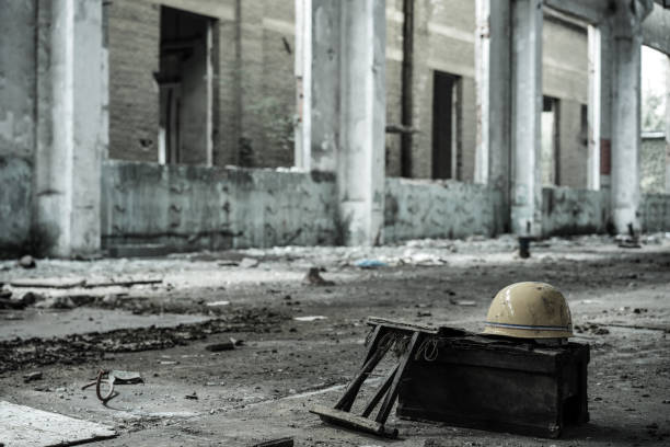 Interior of old factory buildings destroyed. Ruins of industrial enterprise, dark debris destroyed factory premises in factory as result of economic crisis and earthquake.