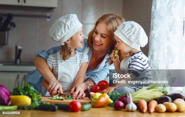 Healthy Eating Happy Family Mother And Children Prepares Vegetable Salad Stock Photo - Download Image Now