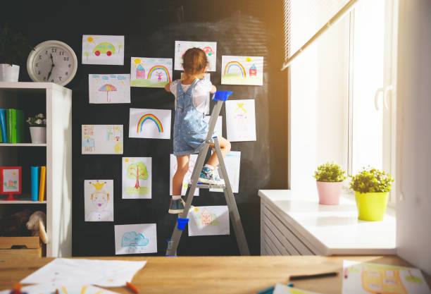 istock child girl hanging her drawings on wall 845509256
