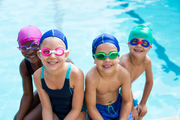 Little swimmers sitting at poolside stock photo