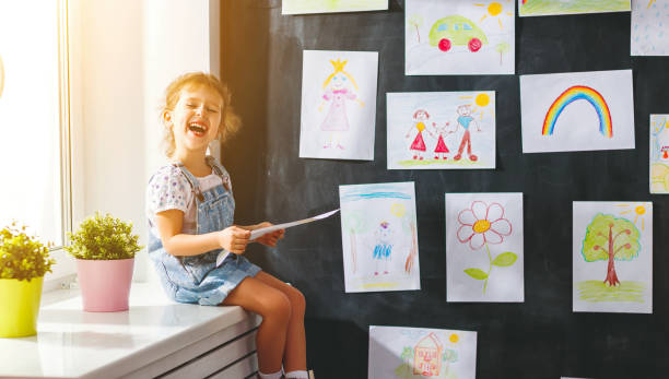 istock child girl hanging her drawings on wall 845509400
