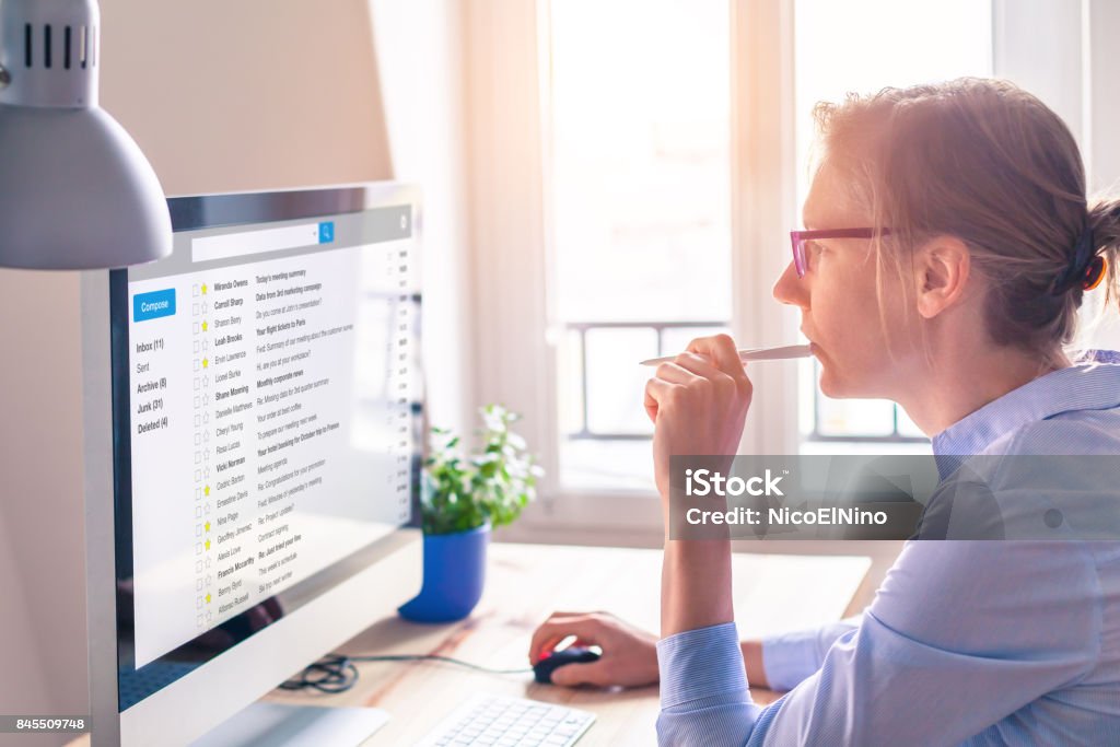 Female business person reading email on computer screen at work Female business person reading email on computer screen at work on internet E-Mail Stock Photo