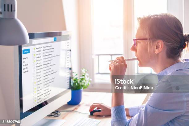 Female Business Person Reading Email On Computer Screen At Work Stock Photo - Download Image Now