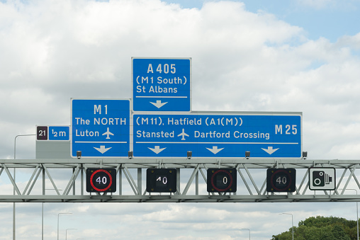 Sign showing what lanes to get into on motorway in England for Luton and Stansted airports and to the North