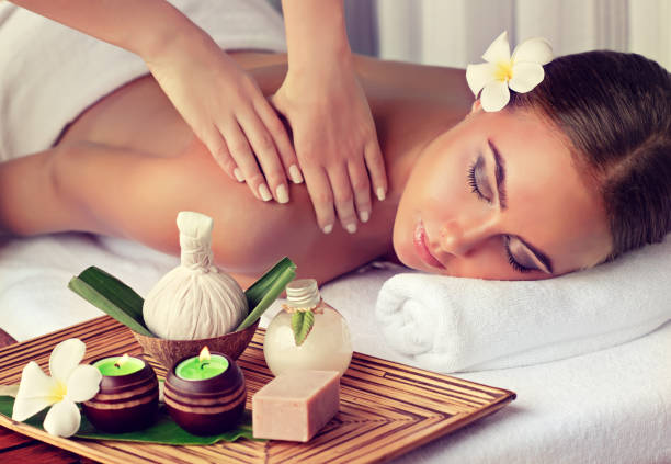 woman is getting massage in the spa salon. - herbal medicine fotos imagens e fotografias de stock