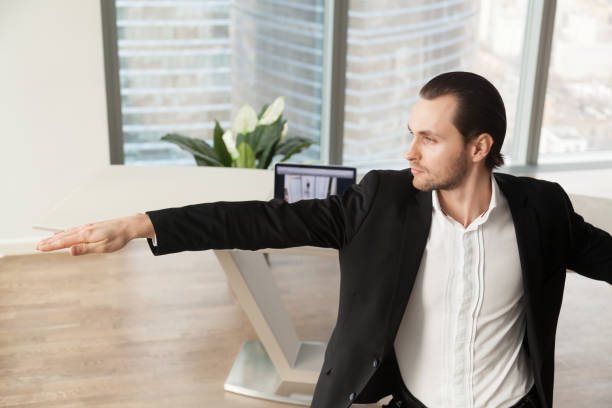 istock Young businessman doing yoga at workplace in warrior pose. 845515958