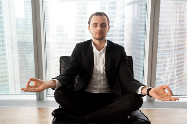 istock Successful businessman meditating at workplace in modern office. 845515972
