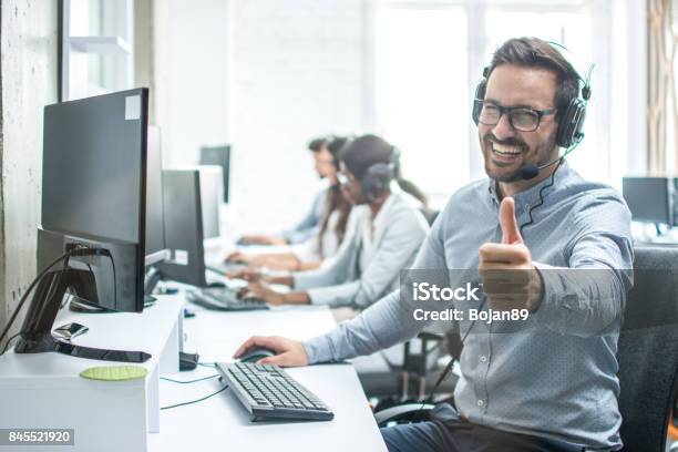 Operador De Servicio De Cliente Masculino Alegre Mostrando Los Pulgares Para Arriba En Oficina Foto de stock y más banco de imágenes de Pulgar hacia arriba