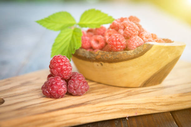 istock Wild raspberry with leaves on wooden background 845523220