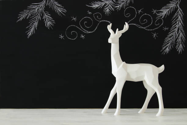 istock White reindeer on wooden table over chalkboard background whith hand drawn chalk illustrations 845523946