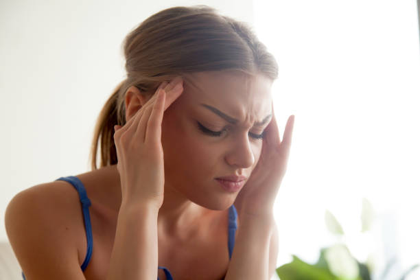 istock Strong headache concept, young woman massaging temples, suffering from migraine 845527186