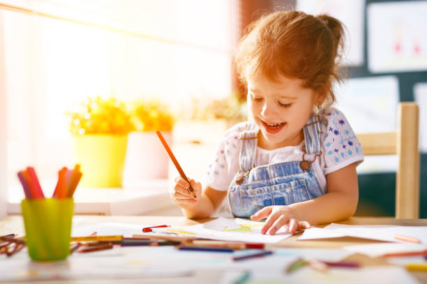 istock child  girl draws with colored pencils 845527518