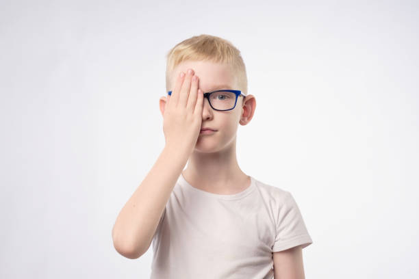 caucasian blond child reviewing eyesight closing half of face with hand. - close up medical test exam people imagens e fotografias de stock
