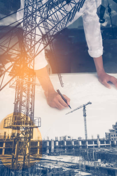 istock Double exposure of  architect working on blueprint with construction site. 845537414