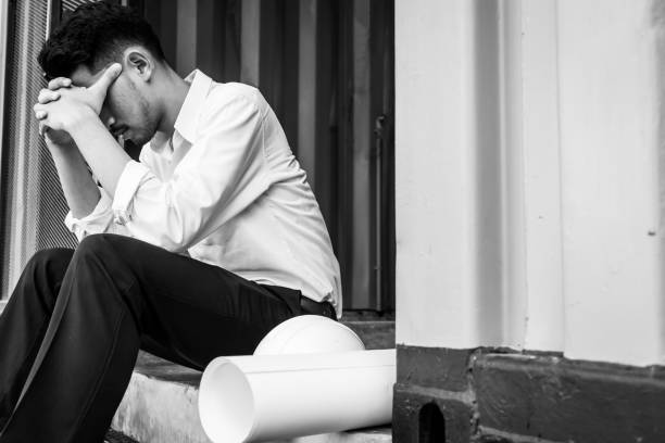 istock Young asian engineer suffering stress working at construction site. Black and White tone 845537426