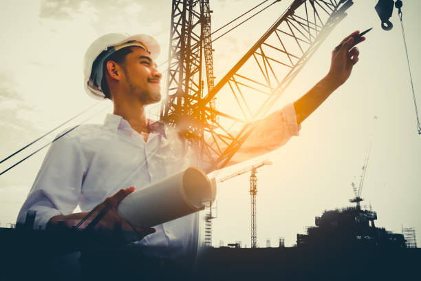 Double exposure of civil engineer holding blueprint with construction site. Double exposure of civil engineer holding blueprint with construction site. civil engineer stock pictures, royalty-free photos & images
