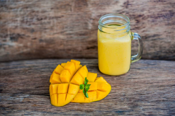 istock Mango smoothie in a glass Mason jar and mango on the old wooden background. Mango shake. 845537782