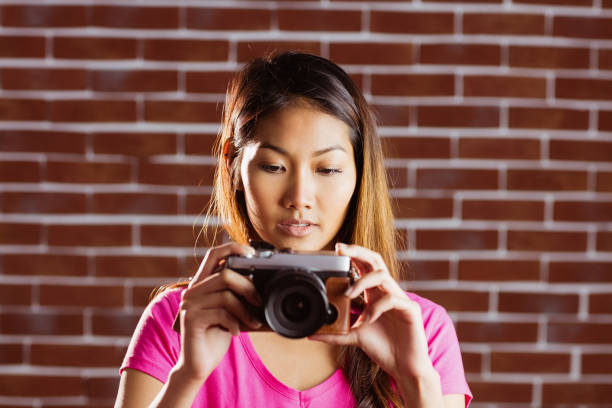 istock Smiling asian woman taking picture with camera 845539142