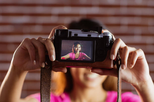istock Smiling asian woman taking picture with camera 845541562