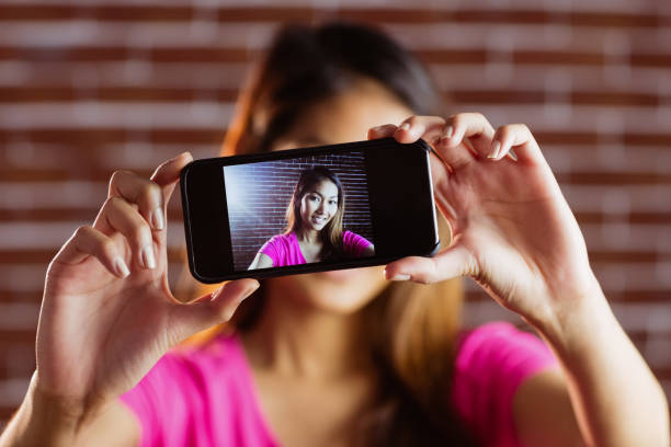 istock Smiling asian woman taking picture with camera 845541616