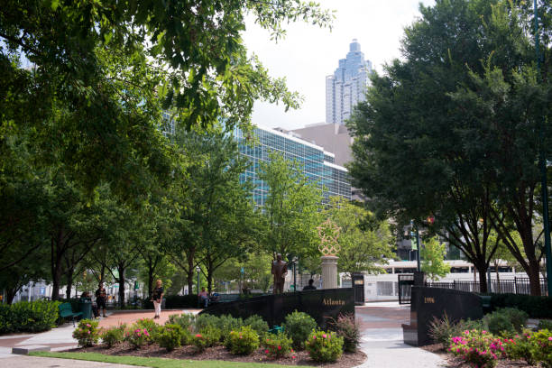 Atlanta, USA - August 12, 2017. People relax at Centennial Olympic Park in downtown Atlanta. Centennial Olympic Park is a public park built for 1996 Summer Olympics and owned by the Georgia World Congress Center Authority. It is a major attraction in downtown Atlanta with a short walk from Atlanta Aquarium and World of Coca-Cola.