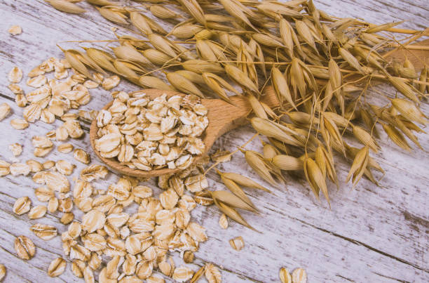istock Raw oat flakes on a wooden table - closeup. 845558166