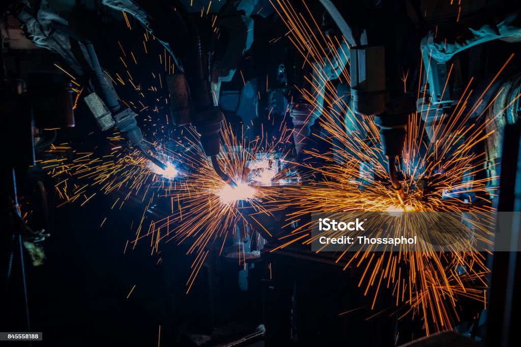 robot is welding in car factory Robot is welding metal part in car factory Automobile Industry Stock Photo