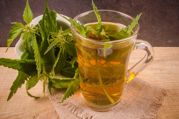 istock Healing tea with nettle. Tea in a glass cup on a wooden table. The source of vitamins. 845559634