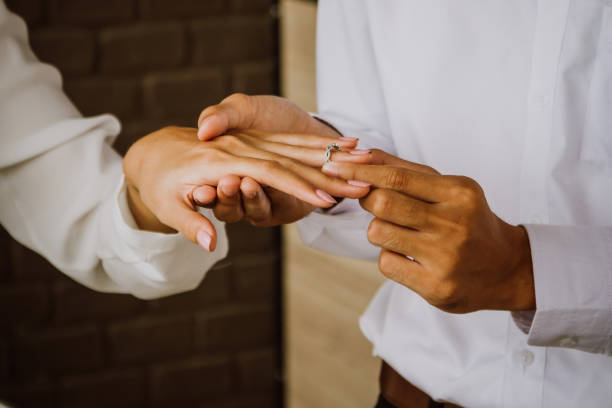 istock Man putting wedding ring on woman hand. 845570456