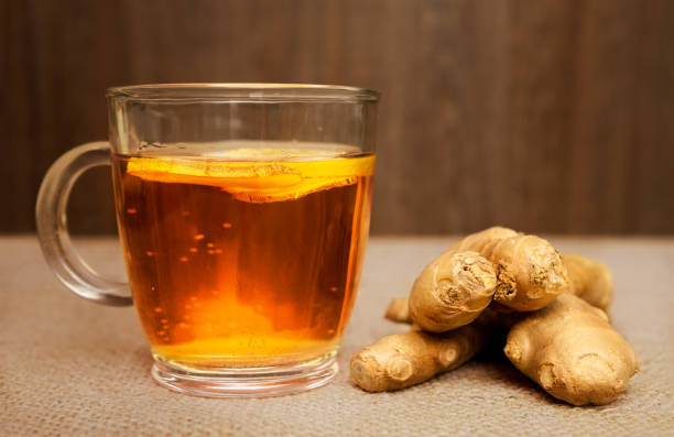 istock Glass of ginger tea and raw ginger on jute 845591848
