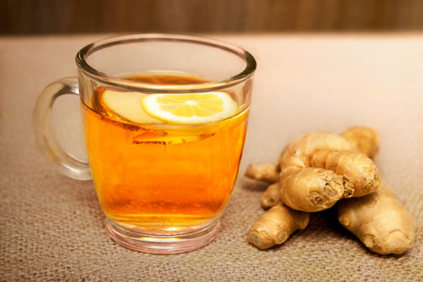 istock Ginger tea in glass and raw ginger on jute 845592058