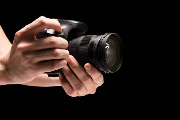 istock Male hand holding a digital camera on a black background. 845594810