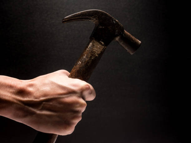 istock Male hand holding hammer on black background. 845594988