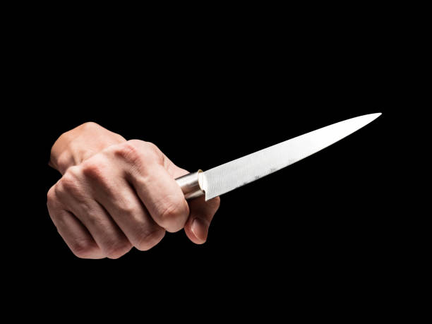 istock Male hand holding knife on black background. 845595000