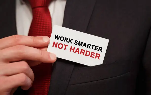 Photo of Businessman putting a card with text Work smarter not harder in the pocket