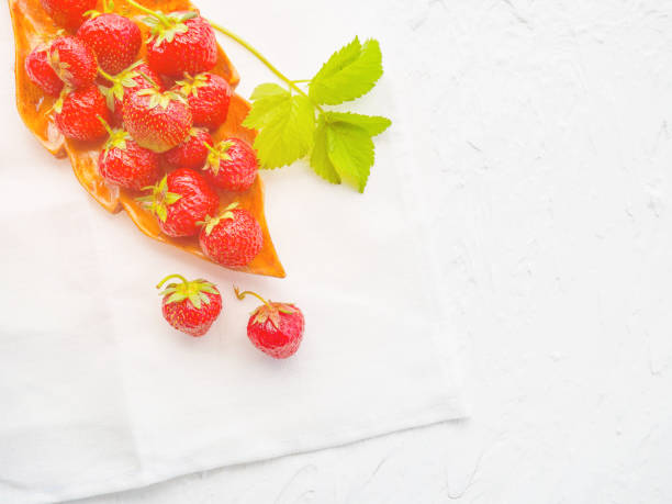 Strawberry. Fresh strawberry. Red strewberry. Strawberry Juice. Loosely laid strawberries in different positions.Fresh strawberries in a bowl on wooden table with low key scene.