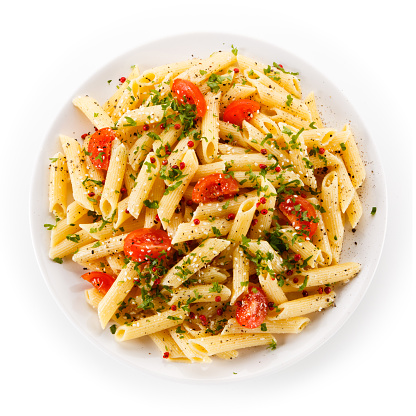 Penne, pesto sauce and vegetables on white background