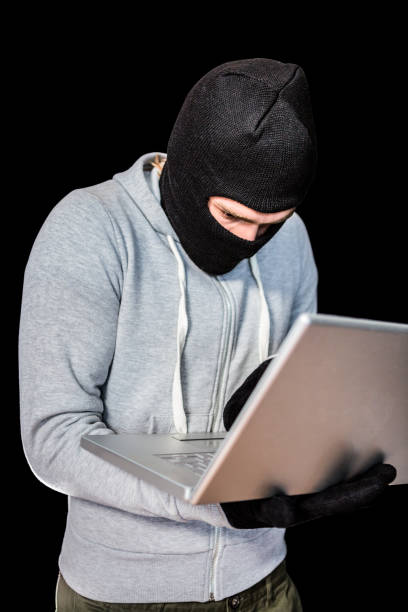 istock Focused thief with hood typing on laptop 845608850