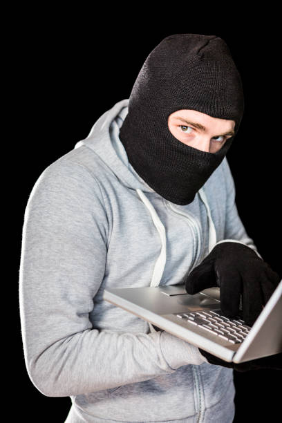istock Focused thief with hood typing on laptop 845608926
